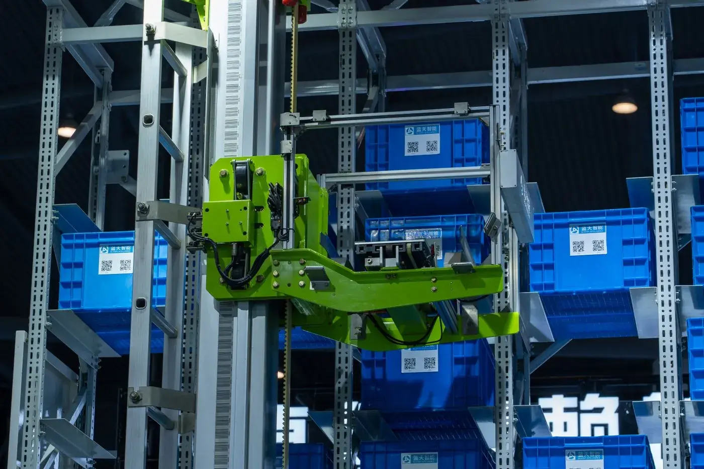 An automated storage system moving blue totes through steel racking.