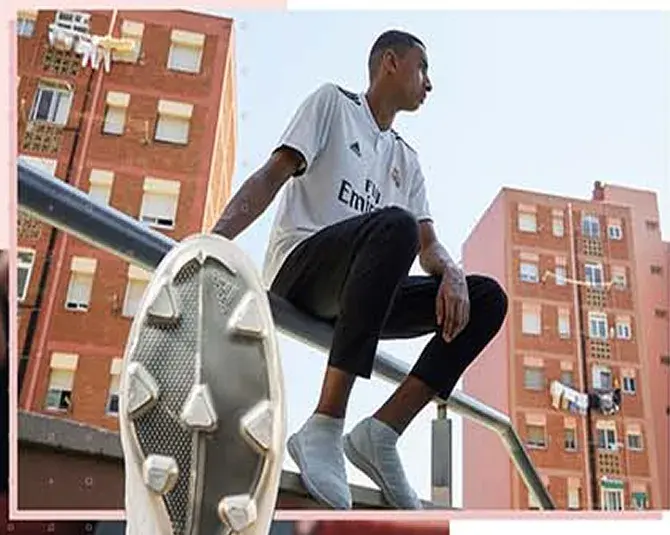 Boot sole held to camera on a rooftop rail above brick housing