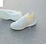 A pair of pale grey knit boots on a concrete floor