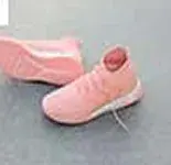 A pair of soft pink knit boots on a concrete floor
