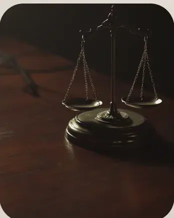 Brass scales of justice on a wooden desk.