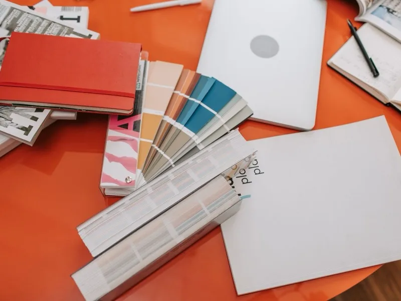 Paper colour swatches fanned out across a studio desk.